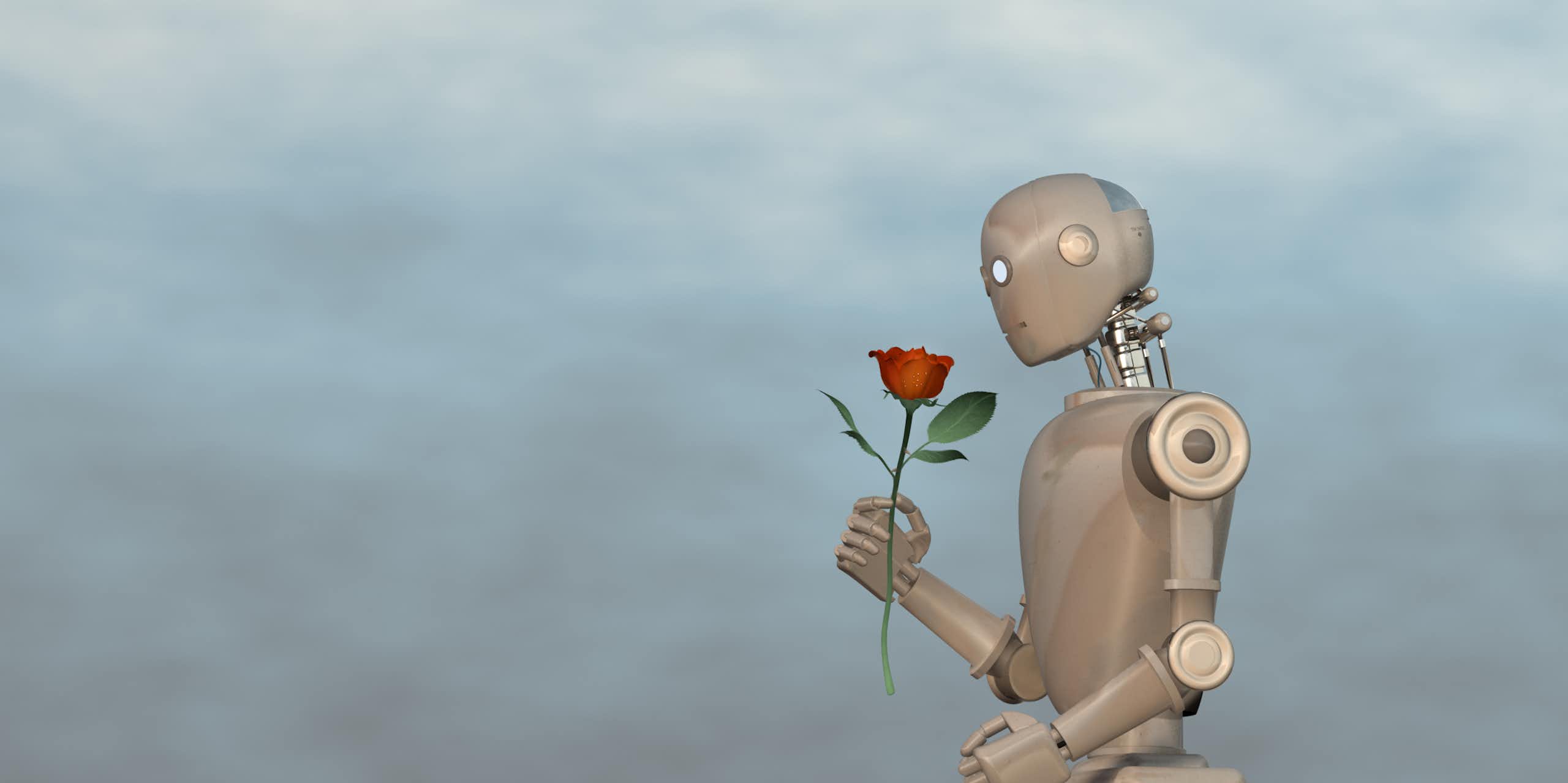 a humanoid robot sitting on a block holding a rosee too its face