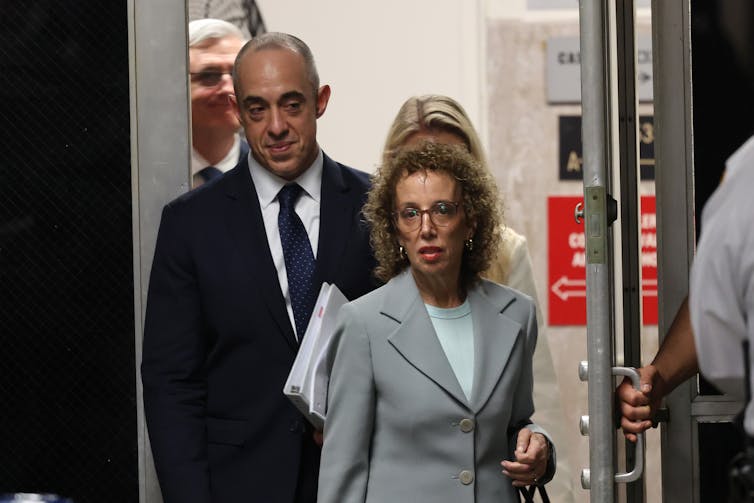 Two people, a man and a woman, enter a building.