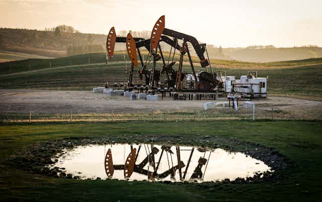 Pumpjacks are pictured under a smoky sky.