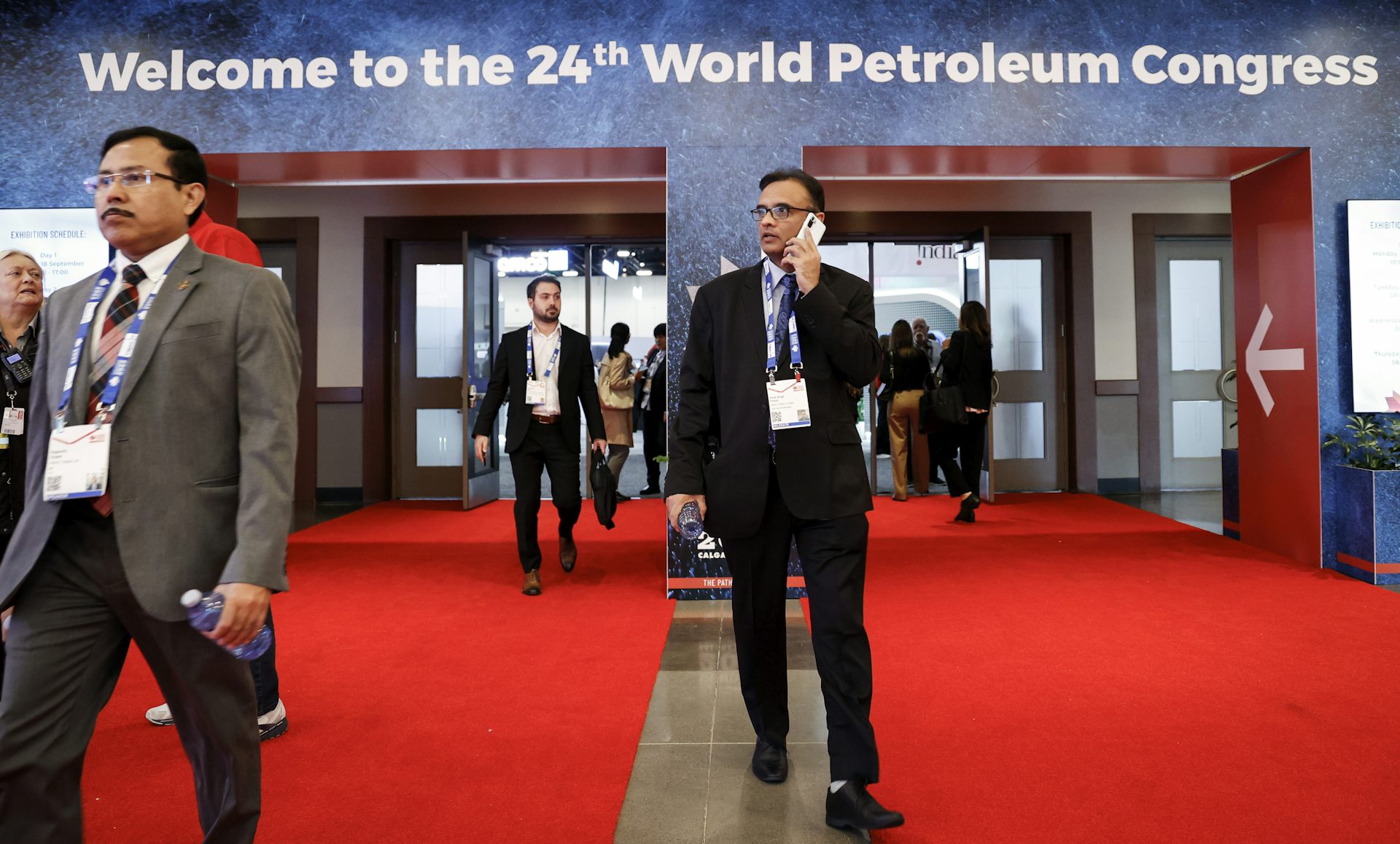 Men in suits walk and mill about.