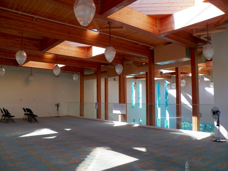 A prayer space on the upper balcony in a mosque a glass railing.