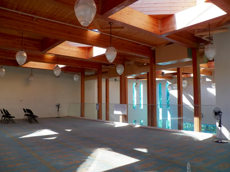 A prayer space on the upper balcony in a mosque a glass railing.