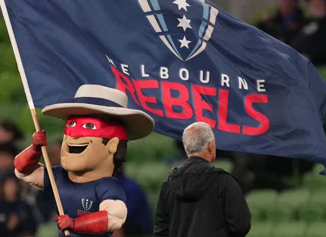 The Melbourne Rebels mascot waves the club flag during a game