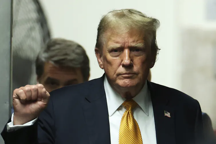 Donald Trump lève son bras gauche et son poing dans les airs