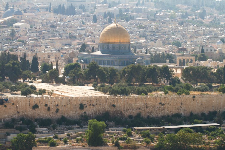 A gold-domed mosque sitting on top of a hill in Jerusalem.