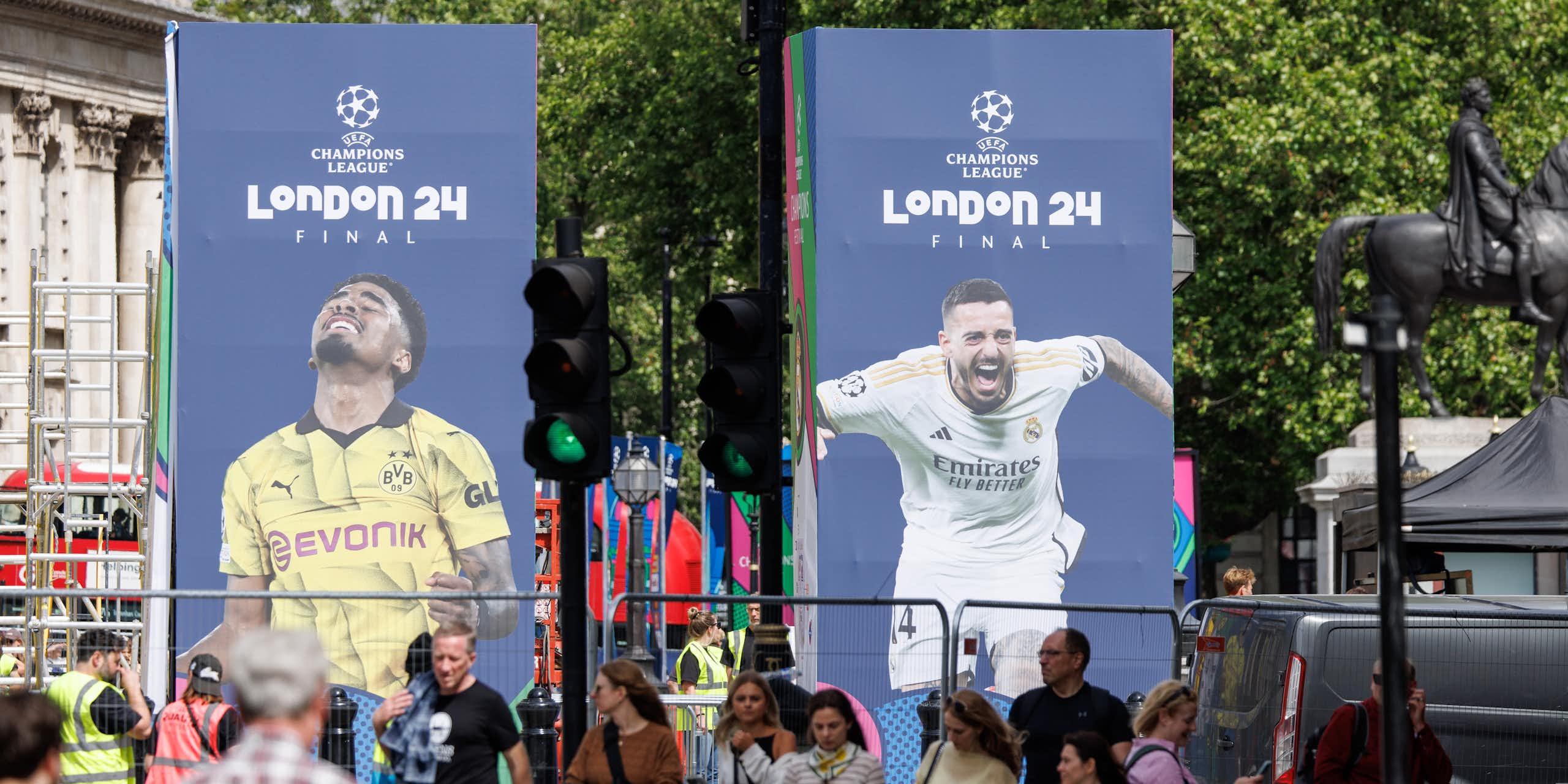 Pedestrians walk past Champions League banners in London.
