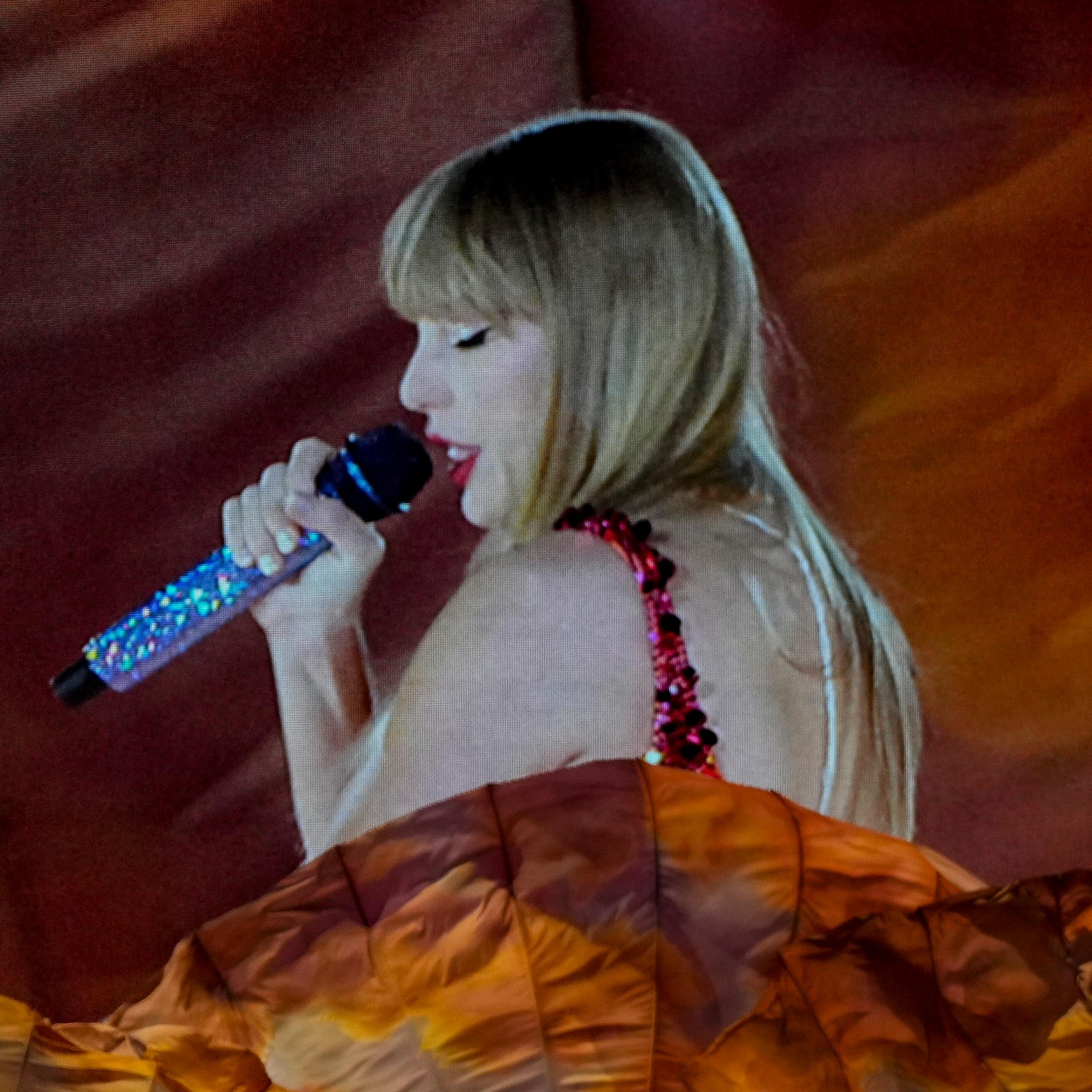 A woman performing next to a huge videoscreen projection of herself.