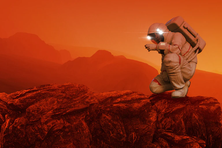 astronaut kneeling on red landscape