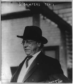 A black and white photo of a man in glasses wearing a tie.