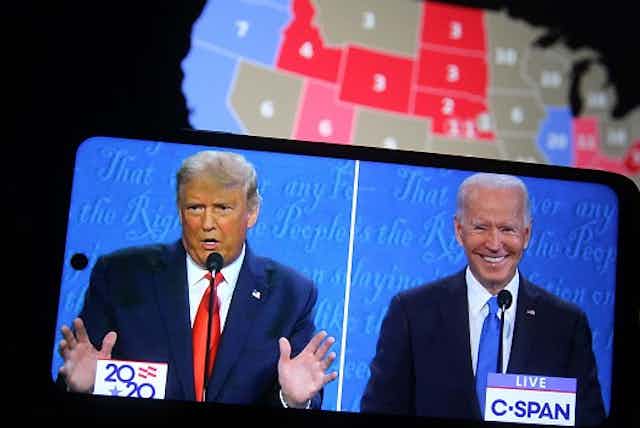 With a U.S. map in the background, images of Trump and Biden appear on a cellphone.