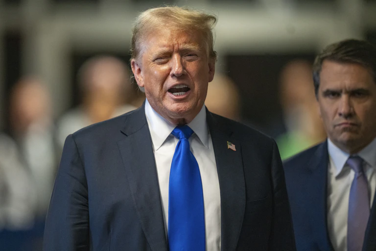 A man in a suit and tie speaks.