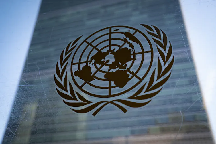 The United nations logo in front of a skyscraper