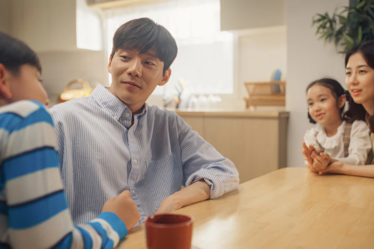 A family holds a meting at the kitchen table.