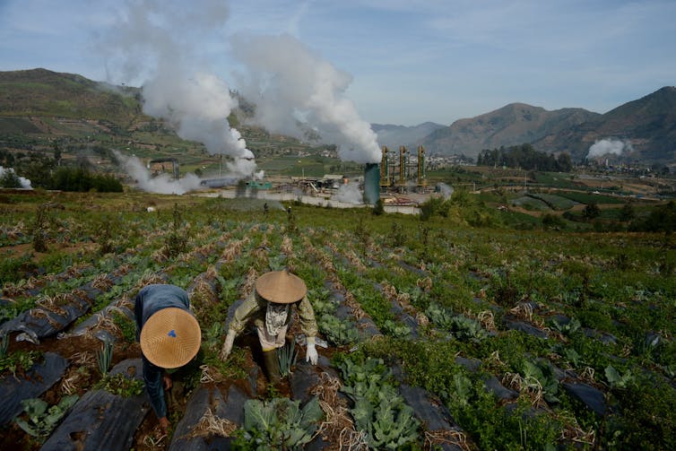 geothermal plant in Java, with farmers in foreground.