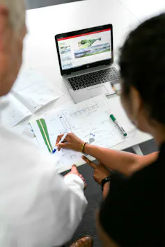 Female civil engineer discusses documents and plans with colleague