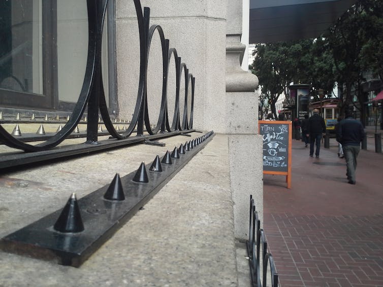 A close-up photo of a ledge on the edge of a building, with metal barriers built into it.