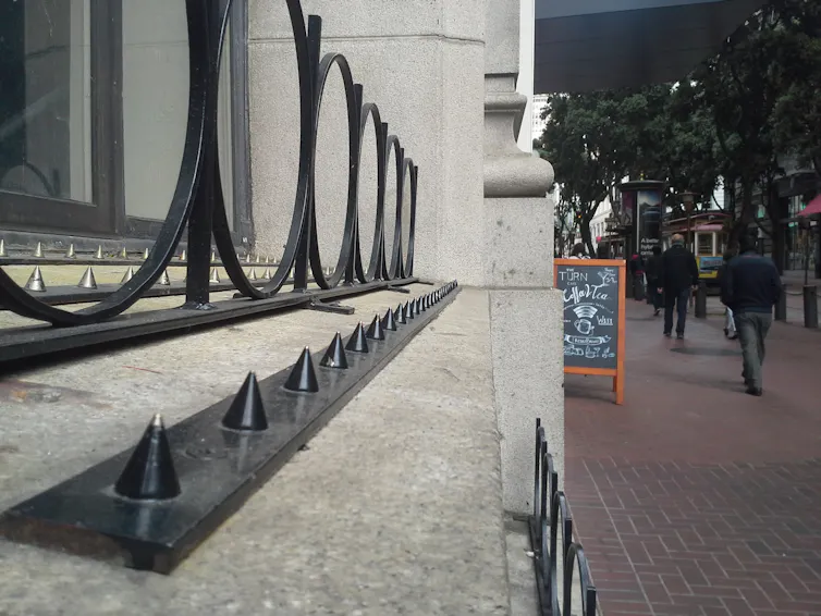 A close-up photo of a ledge on the edge of a building, with metal barriers built into it.