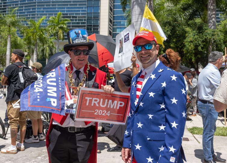 Trump supporters wearing hat and jackets reflecting the US flag.
