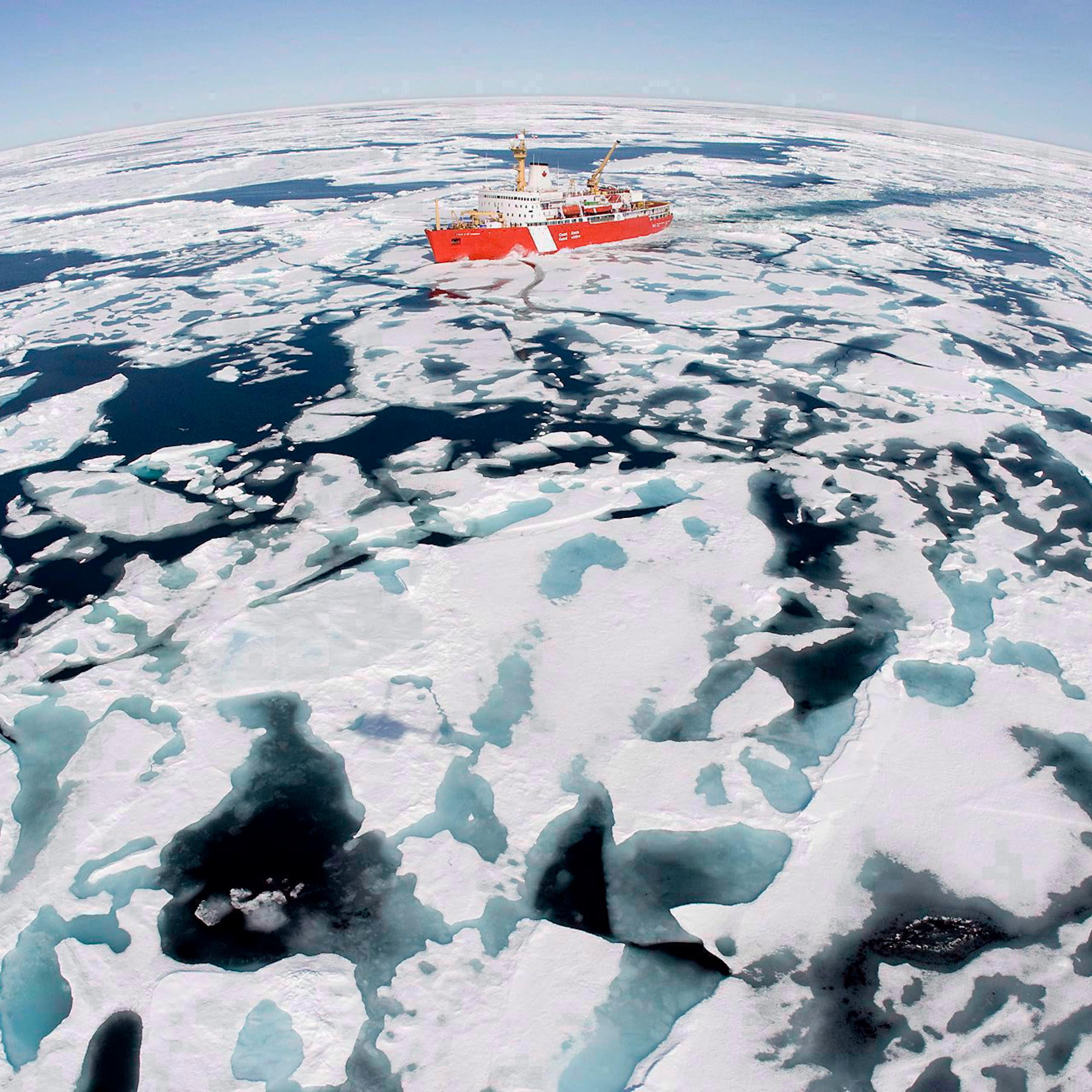 A red boat makes its way through ice-studded water.