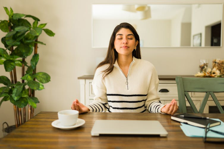 A woman sitting at a table meditating