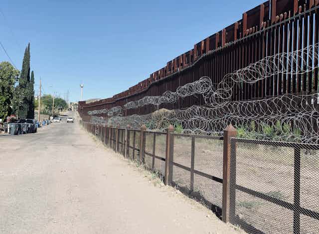 border wall with barbed wire and gates
