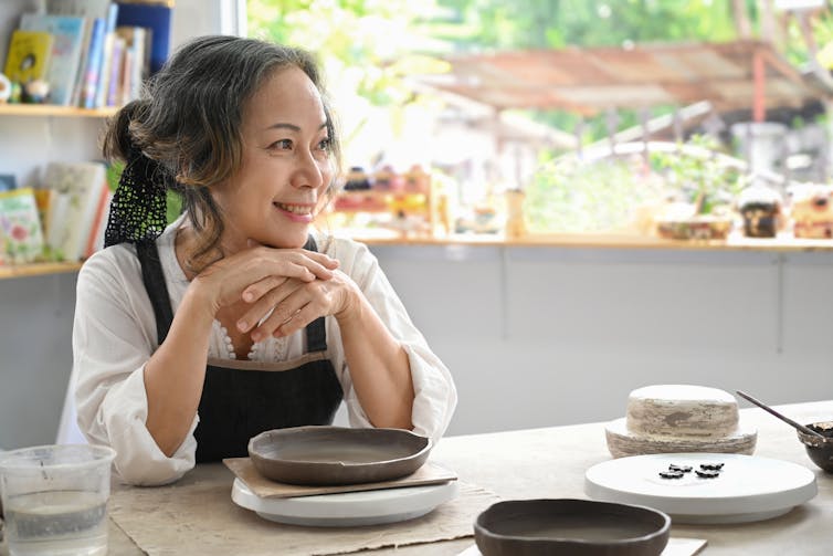 A woman is smiling at a table.