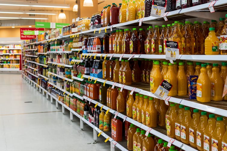 Shelf-stable orange juices on a supermarket shelf