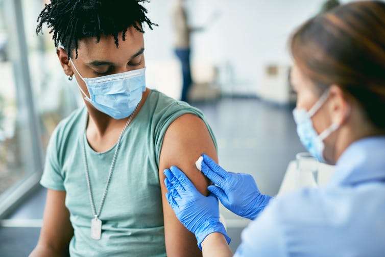 A young man receives a vaccination.