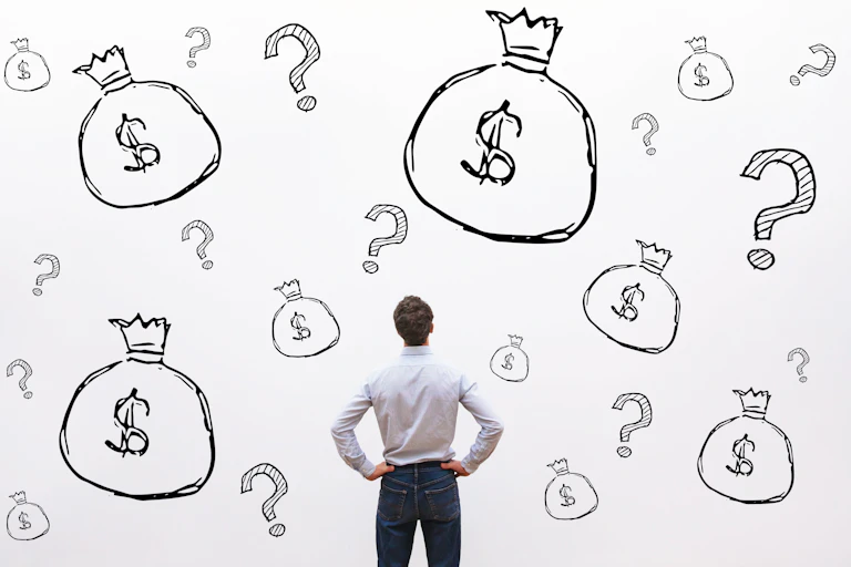 Man staring at wall painted with numerous images of bags of cash