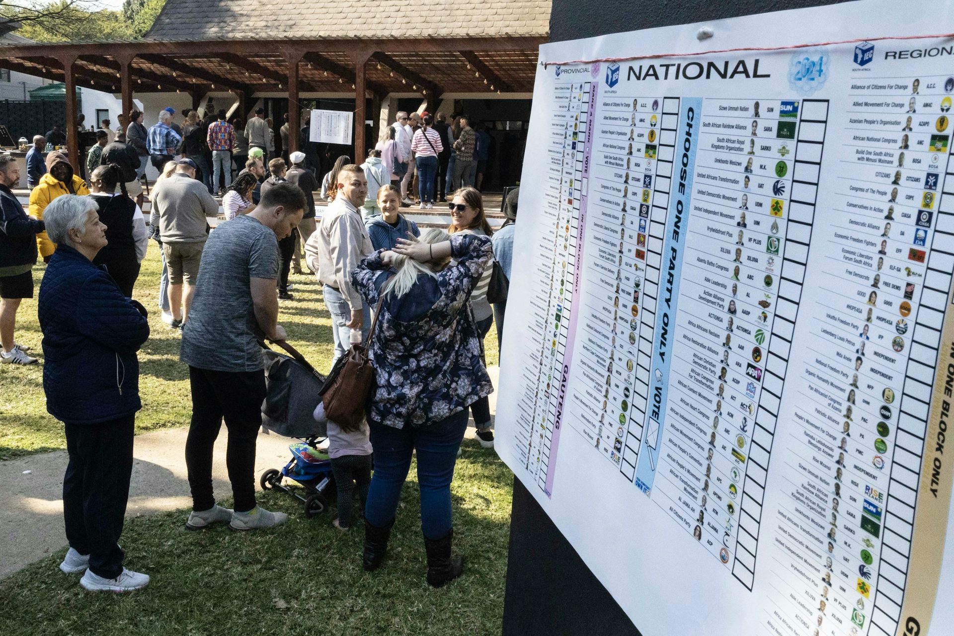 People file past a voting display board outside