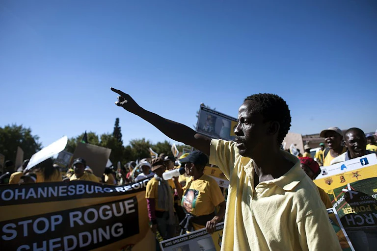 People outdoors, holding banners and gesticulating