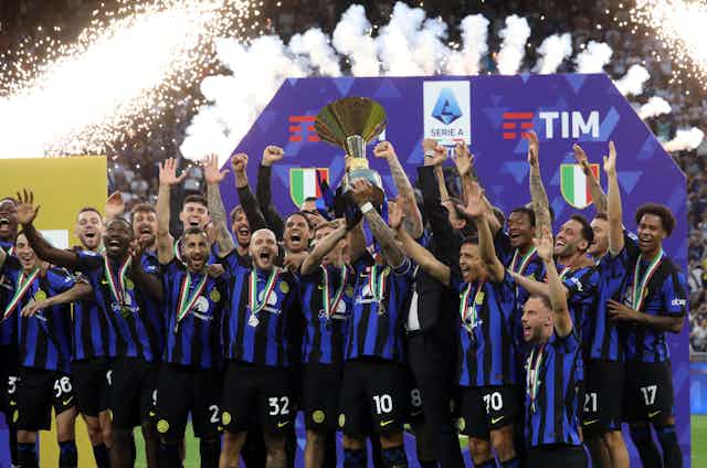 Inter Milan's squad celebrate as they lift the league winner's trophy.