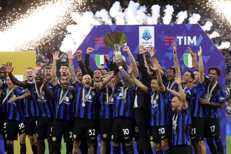 Inter Milan's squad celebrate as they lift the league winner's trophy.