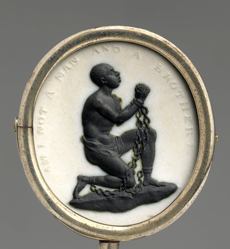 A medallion featuring a kneeling and shackled Black man with the inscription, 'Am I not a man and a brother?'