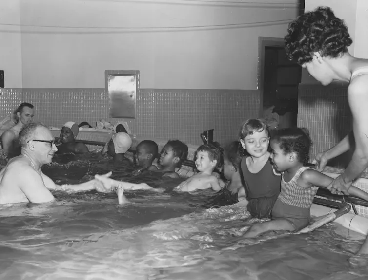 Black-and-white photo of young children in pool