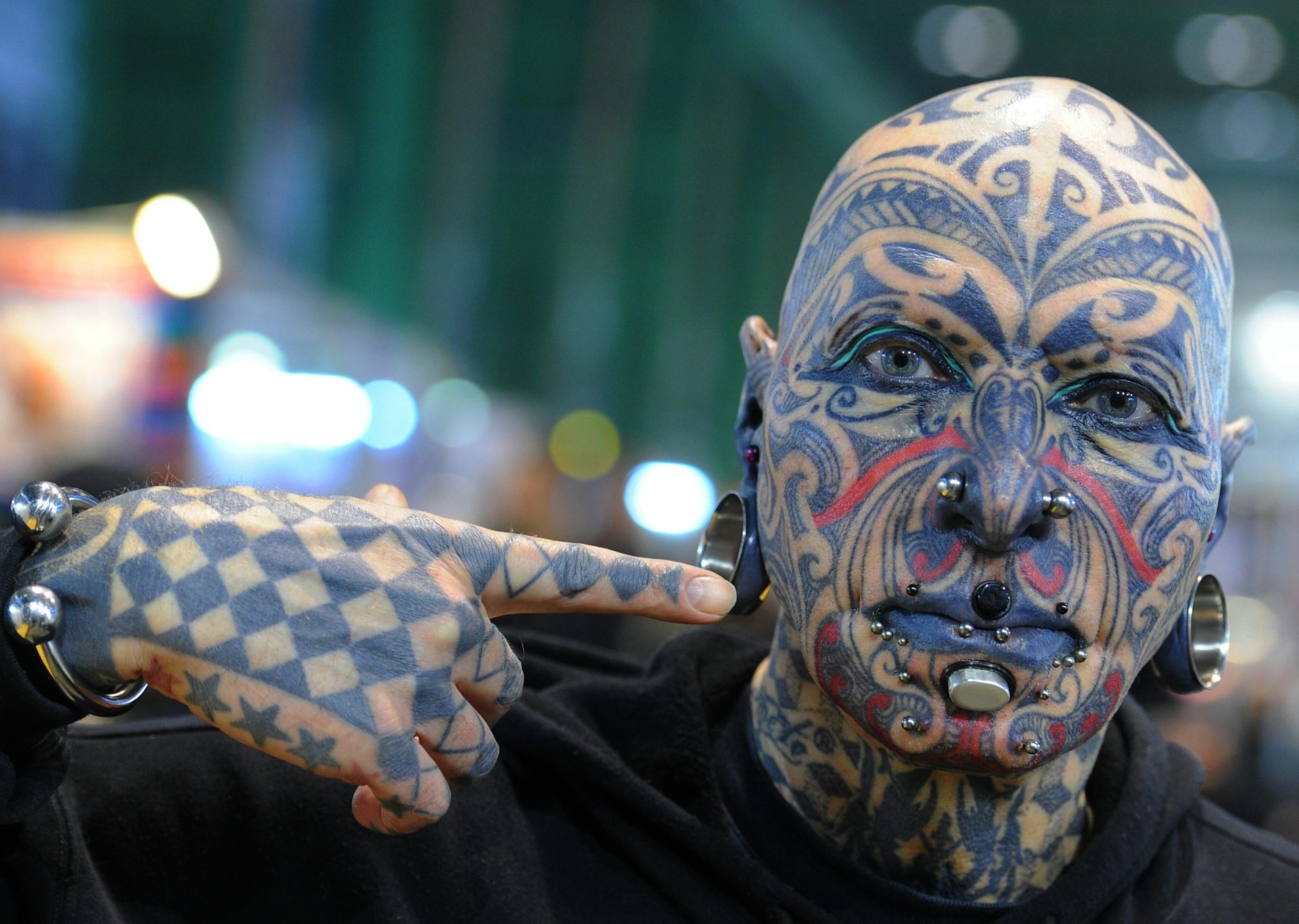 A person with a tattooed face and hands.