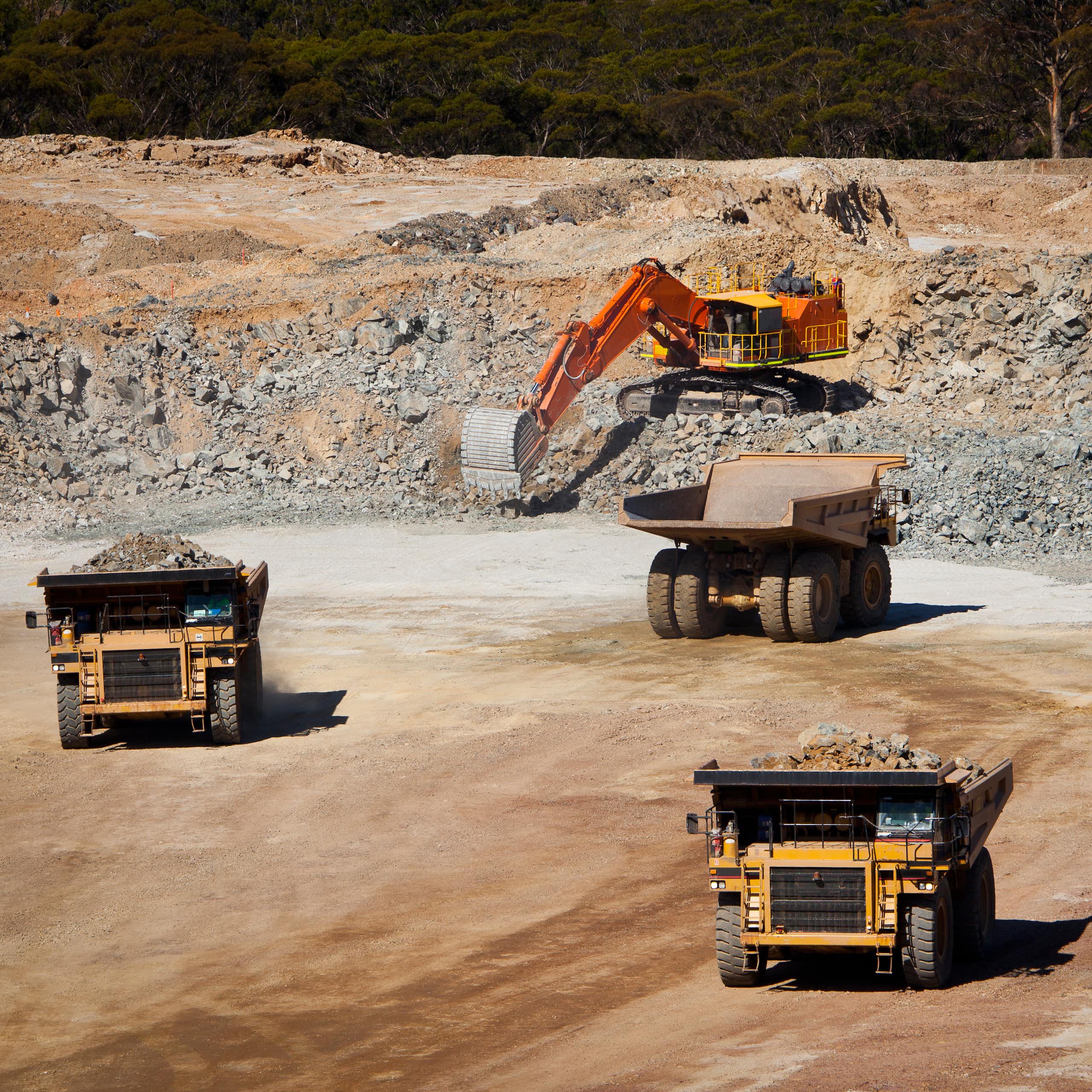 Trucks at an open cast mine with digger in background