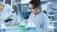 Woman scientist using a dropper to put fluid in a test tube