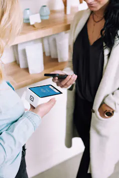 Woman makes EFTPOS payment using phone