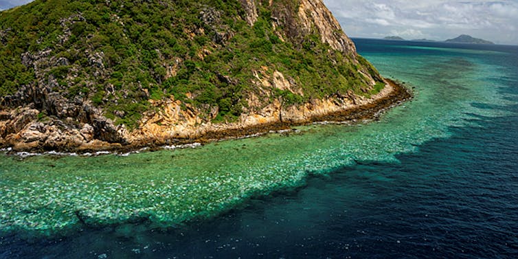 Aerial image of a tropical landscape surrounded by coral reef