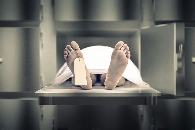 Dead man in a morgue with toe tag