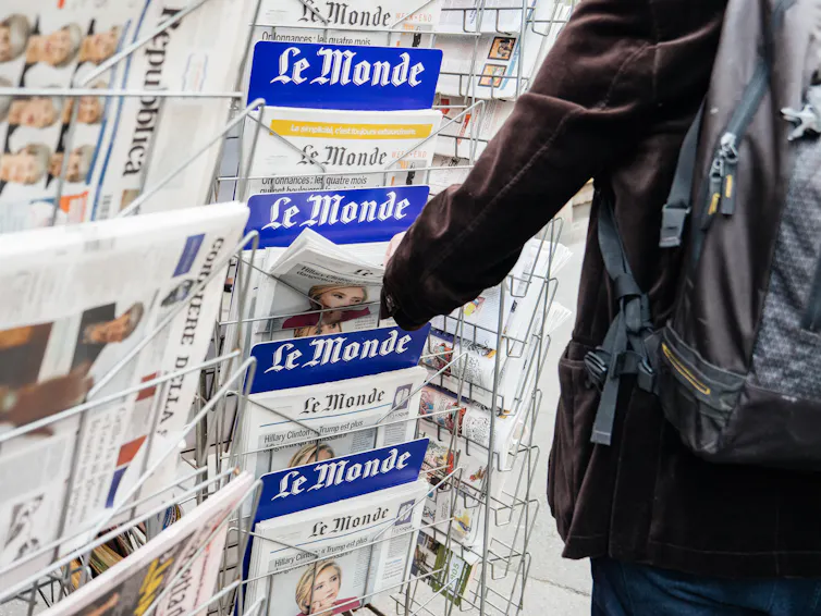 Un homme achète le journal français Le Monde dans un kiosque de presse à Paris en sepetembre 2017