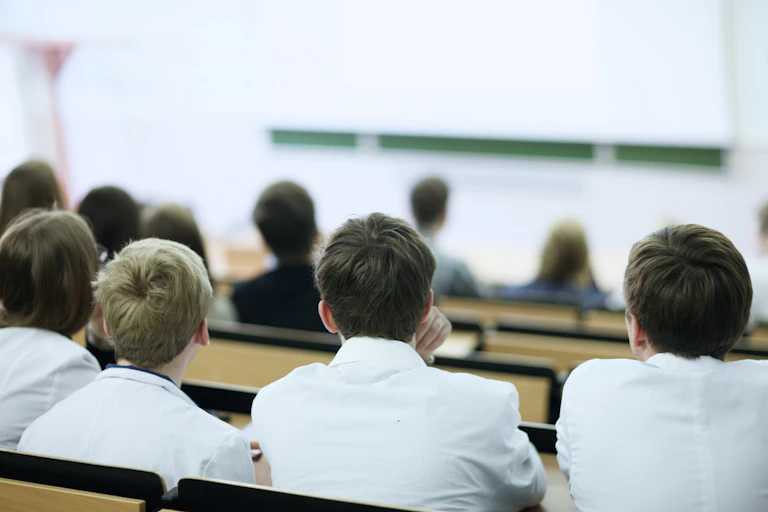 Des étudiants en médecine, de dos, suivent un cours.