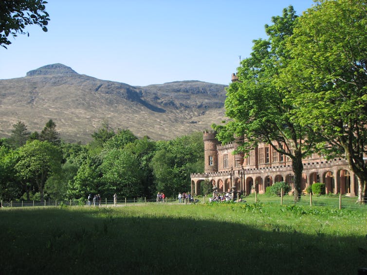 rugged Scottish landscape, grand building on left with green trees