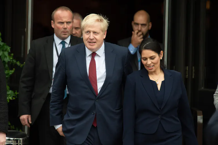 Johnson and Patel walking and talking side by side.
