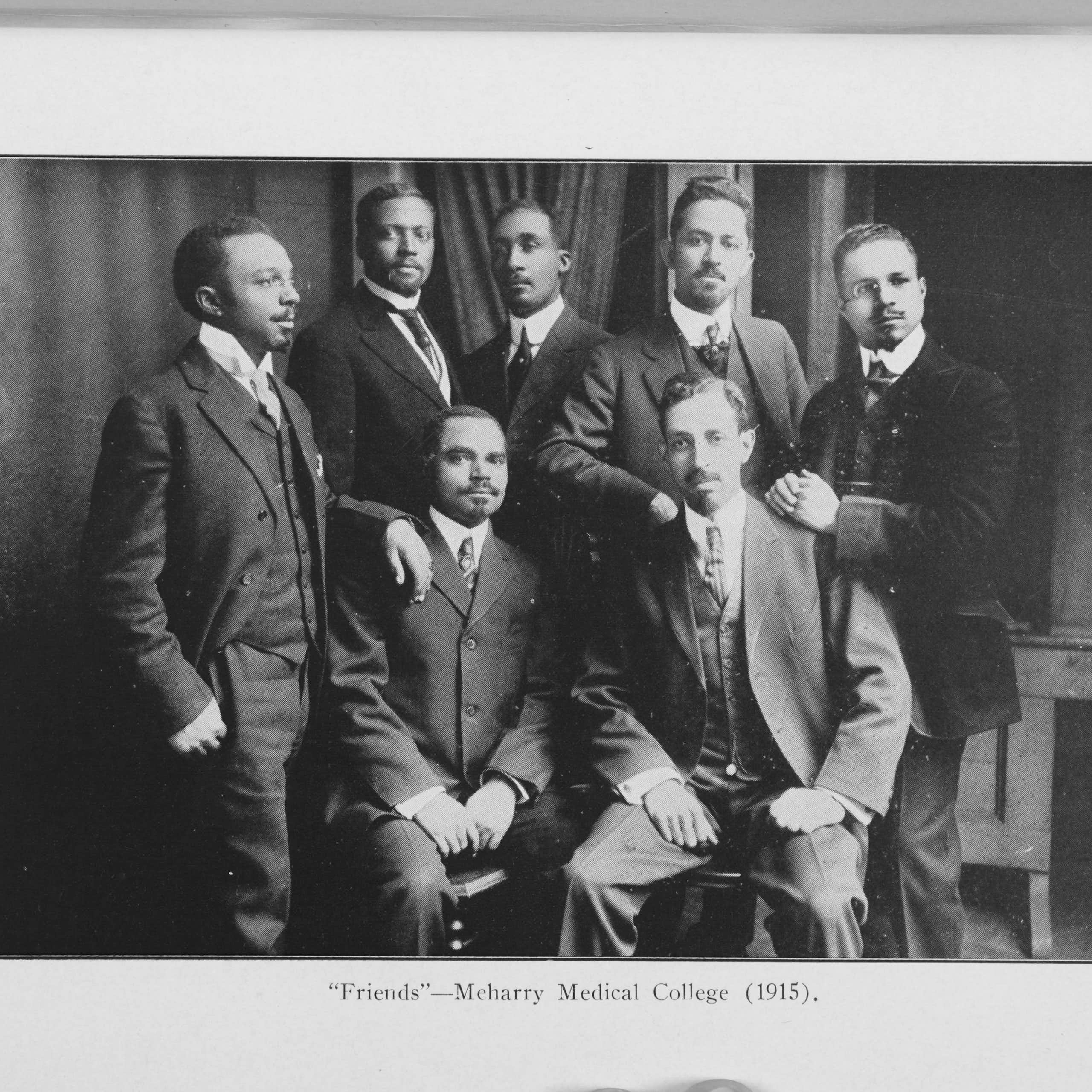 A group of seven Black men are dressed in business suits.