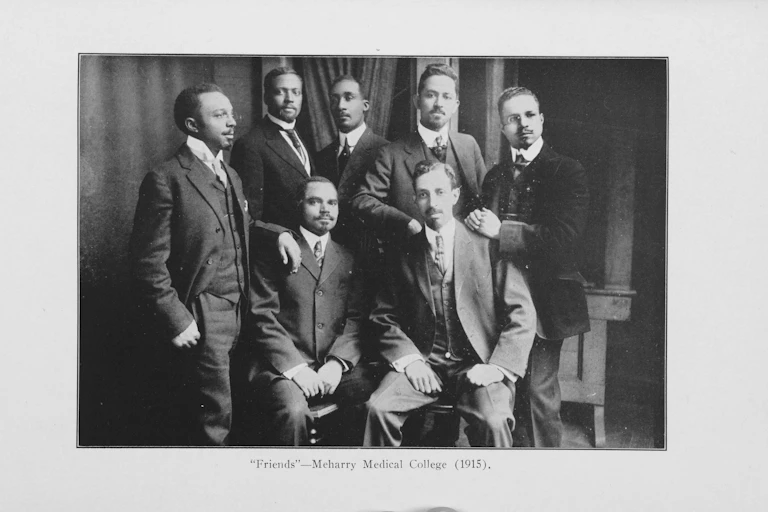 A group of seven Black men are dressed in business suits.