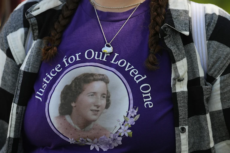 A woman wears a purple shirt with a face of an older woman on it