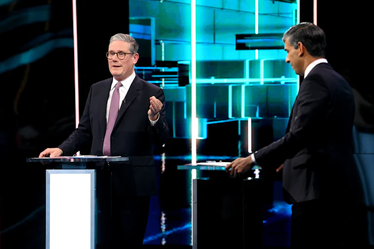 Keir Starmer and Rishi Sunak standing at podiums in a TV studio.