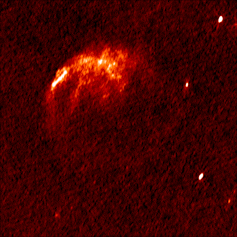 Uma imagem animada que mostra uma região escura do espaço com uma nuvem de vermelho brilhante e o que parecem ser três estrelas fixas e uma que pisca lentamente.